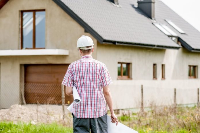 Stavebník s plány před rodinným domem - Ilustrační foto WIRTUU