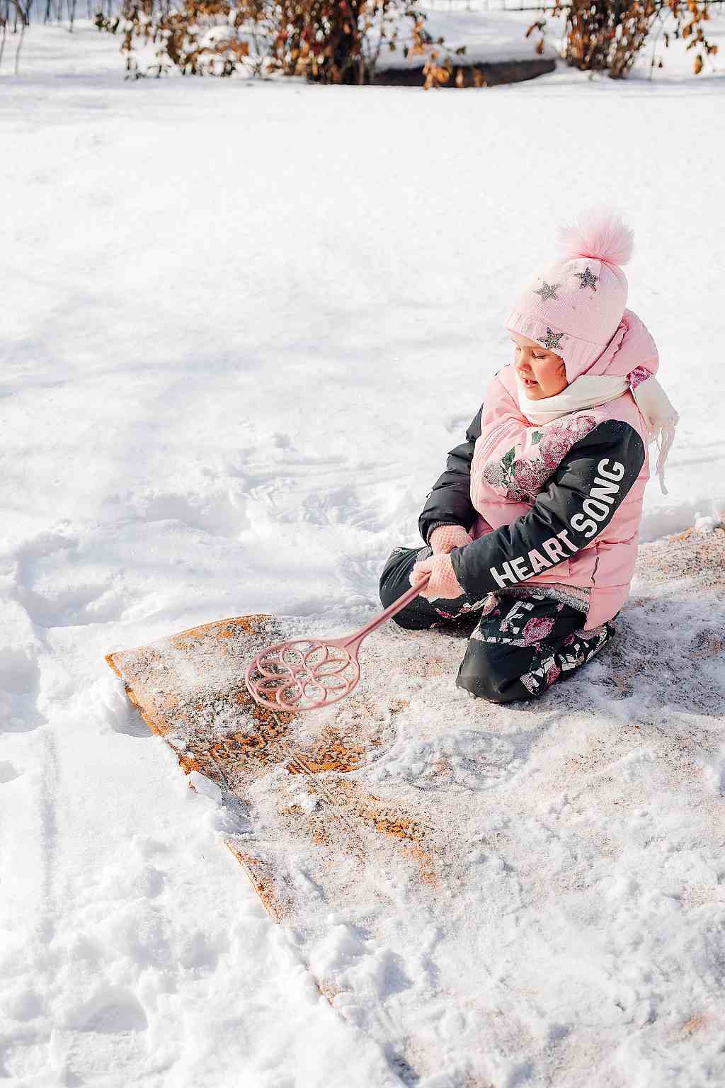 Čištění koberců sněhem, dítě - ilustrační foto