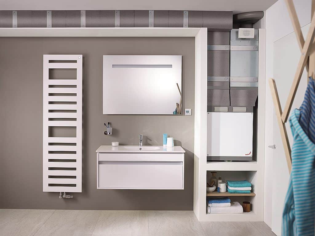 Centrální větrací jednotka Zehnder ComfoAir 180 ve skříňce ve výklenku v koupelně (viditelné rozvody)